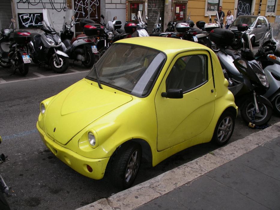 A smart car surrounded by motorcycles in downtown Rome. Smart cars are a common sight in the big cities.  Photo by Don Quilici