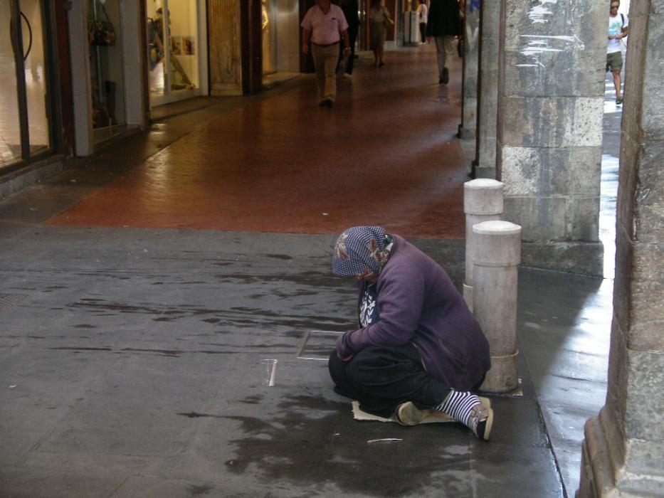 A beggar woman waiting for money in Venice.  Street beggars are everywhere in all of the big Italian cities.  Photo by Don Quili