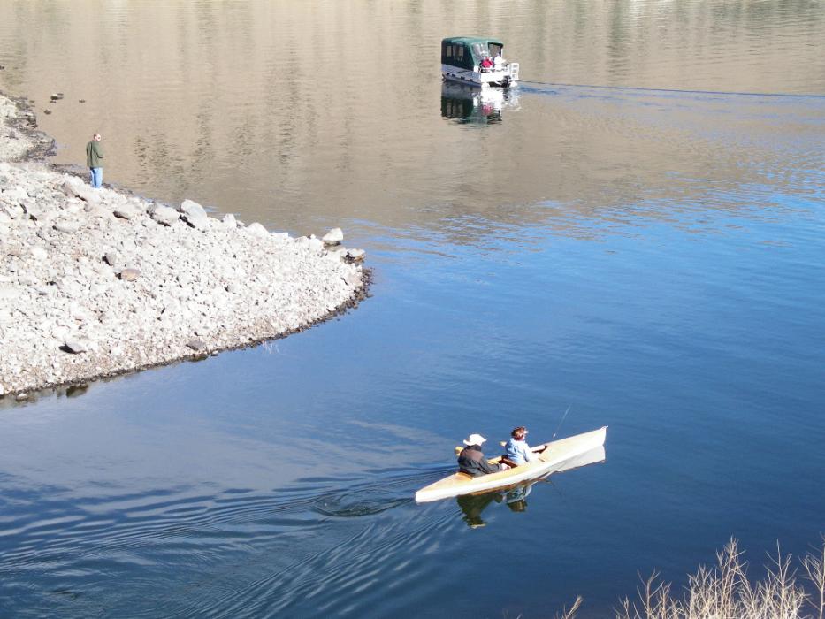 An interesting mix of a solitary shore fisherman, a kayak entering the lake and a passing fishing boat.  Photo by Elaine Quilici