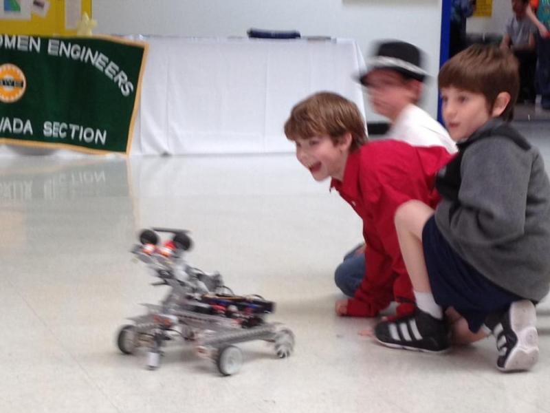 Some young spectators play with a demonstration robot