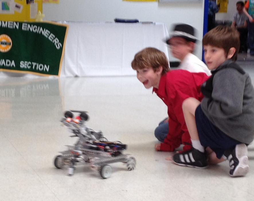 Some young spectators play with a demonstration robot