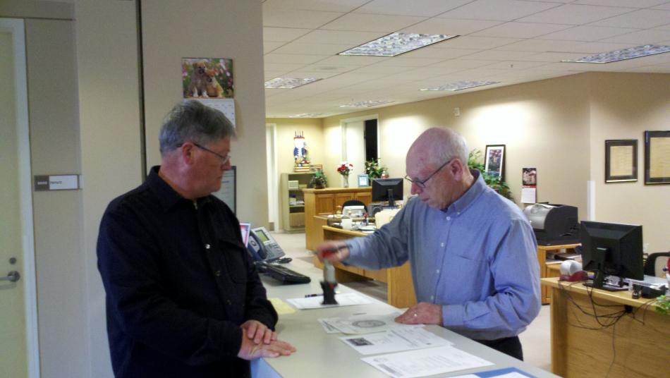 Dennis Johnson, left, files his paperwork with Recorder Alan Glover to run for Carson City Supervisor