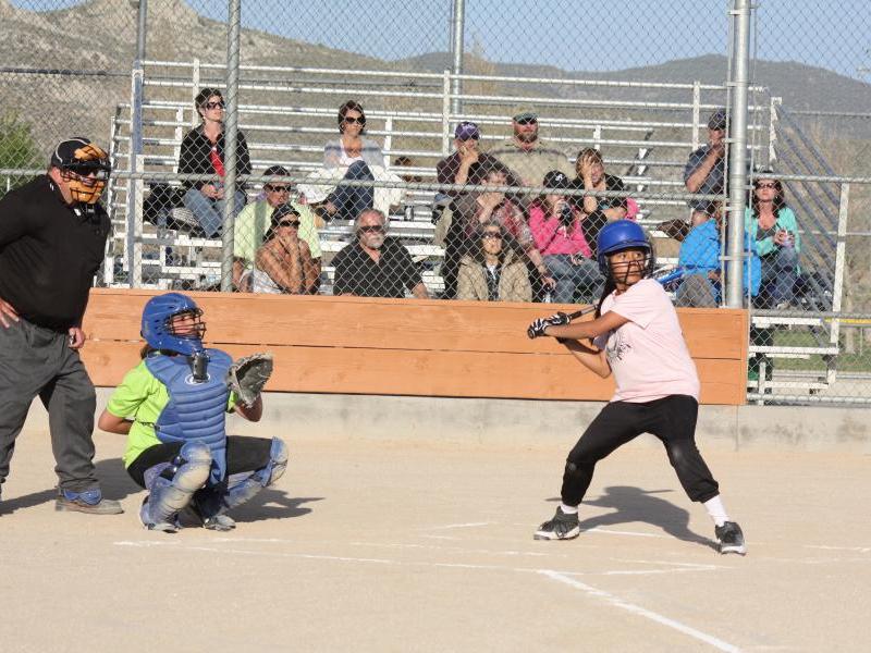Tezia Boice hitting a line drive with Killer Kiwi catcher Kassidy Cooley looking on