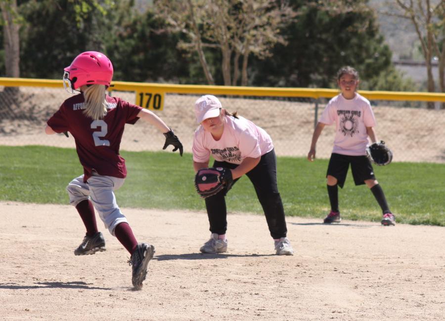 Savanna Sharp fielding at 2nd with backup by Annabelle Crawford and baserunner Mak Wells
