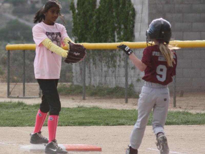 Hitha Segu putting out Grace Miller of the Little Devils at 1st base.