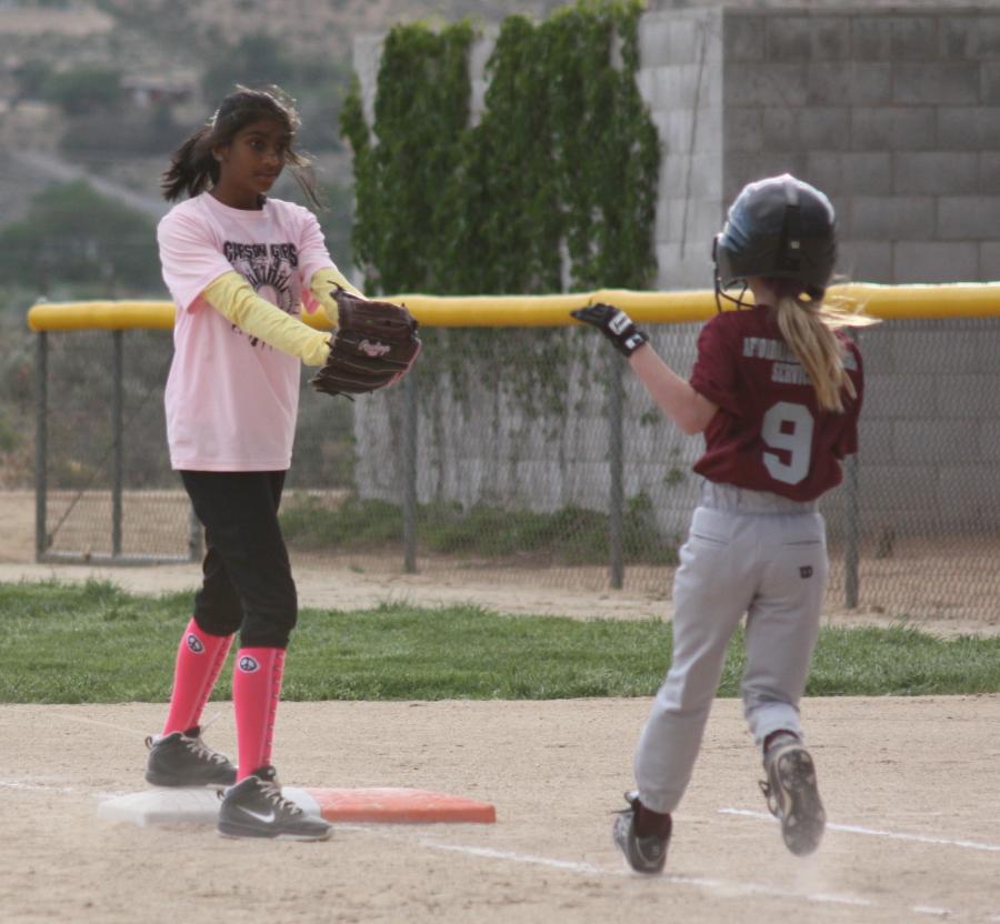 Hitha Segu putting out Grace Miller of the Little Devils at 1st base.