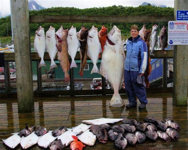 Susan Drury of Watson Lake, Yukon stands next to her 145 pound Halibut caught at Valdez, Alaska. Photo by Barry Drury