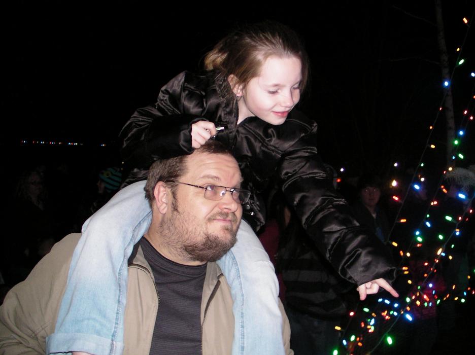 Jeff Querl holds daughter Kaitlyn, 8, at the same tree he did in 2010.
