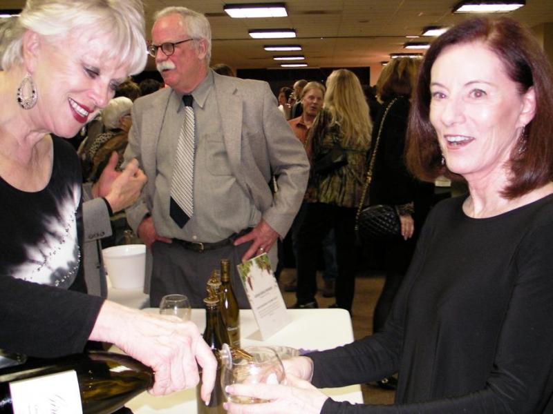 Carson City Chamber Director Ronni Hannaman pours for Susan Crowell, wife of Carson City Mayor Bob Crowell.