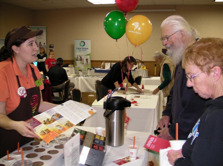 Abra Teague, owner of Jamba Juice on Topsy Lane gives a refresher and samples to Margo Conway and Bill Meyer.