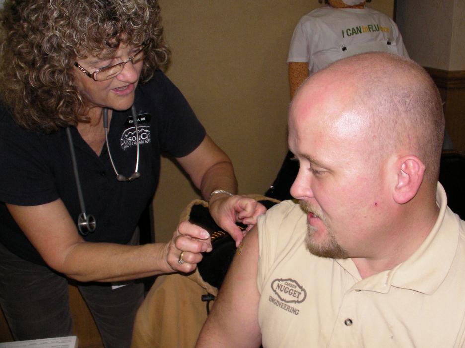 RN Karen Allen with Carson City Health & Human Services gives Jason Bratt of Carson City a free flu shot.