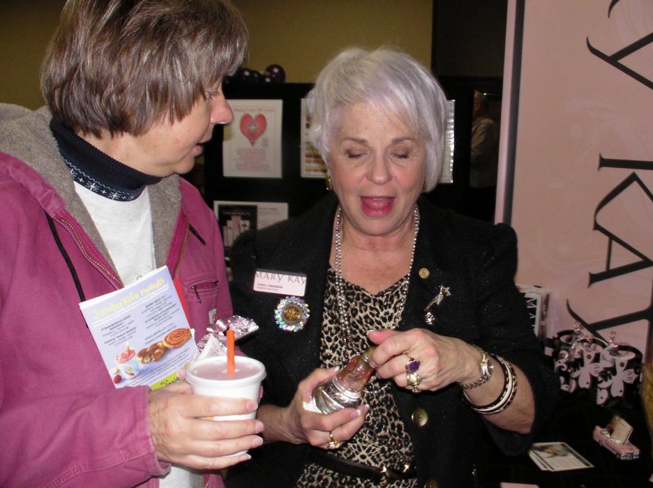Wendy Holden samples perfume from Mary Kay independent sales coordinator Carol Swanson.