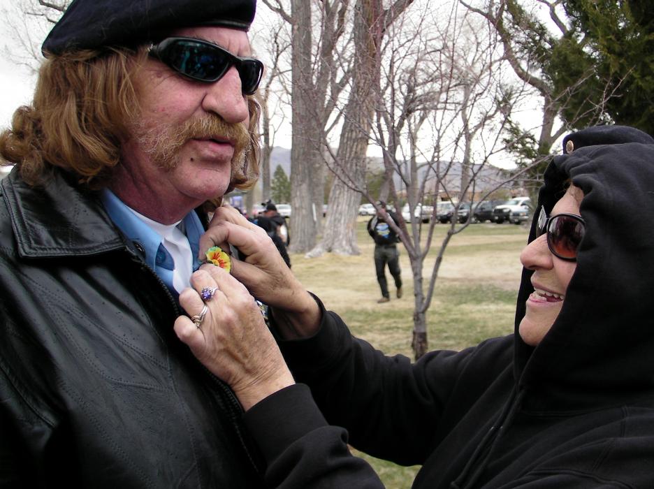 Rick Kaspar, a veteran and member of the Honor Guard, is helped by wife Debbie with a Vietnam Day poppy.