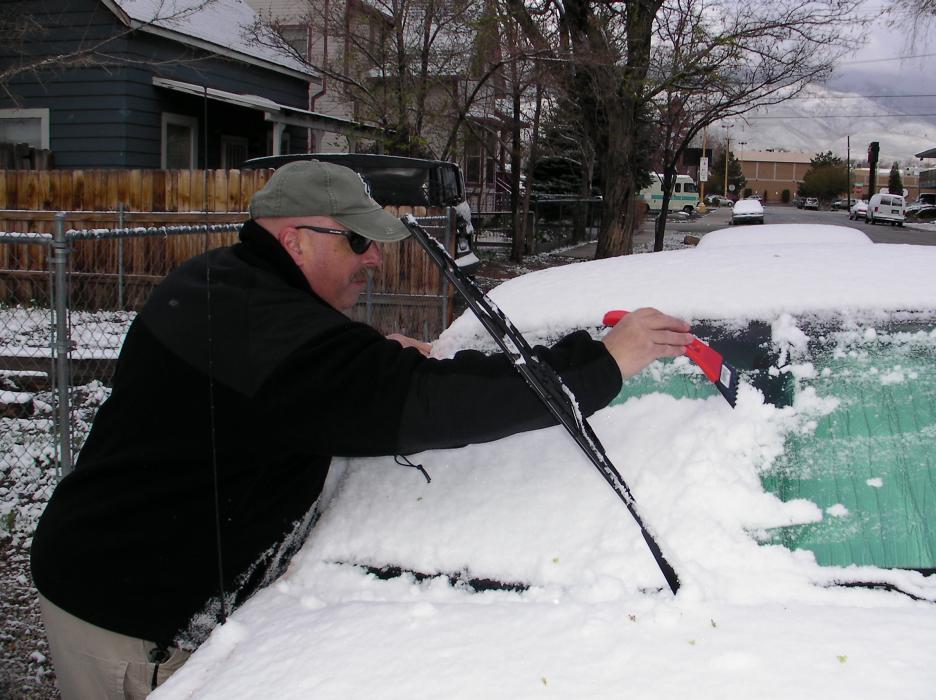 Andy Notar dusts off his car Tuesday morning on Valley Street.
