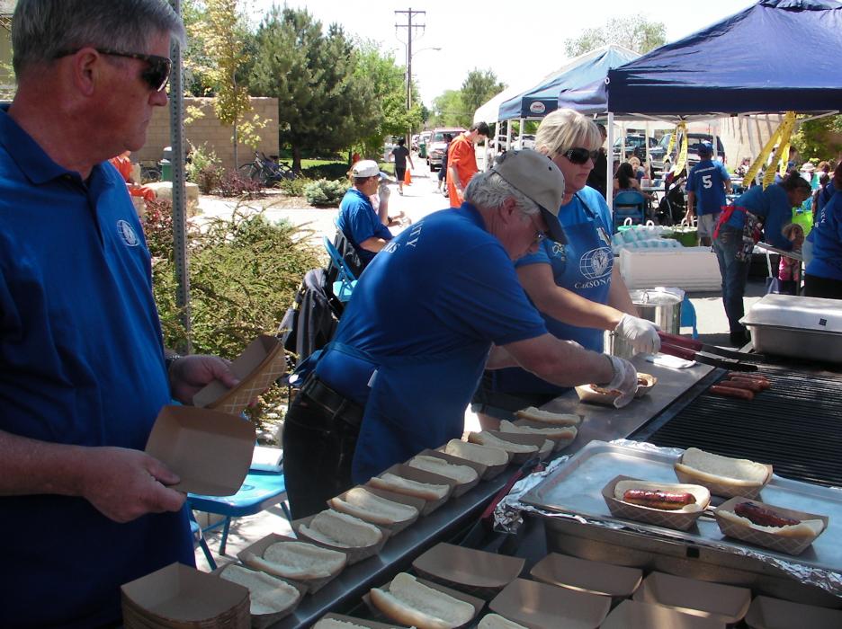 Carson City Kiwanis Club members Dennis Johnson, Fred Webb and Cheryl Knight barbecue hot dogs provided by Grocery Outlet.