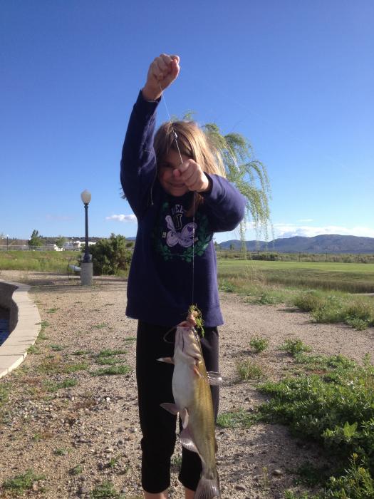 Sandra Tubiello, 8, holds her first-ever-fish, a catfish caught in the pond at the Silver City RV Resort. Photo by Chris Utley
