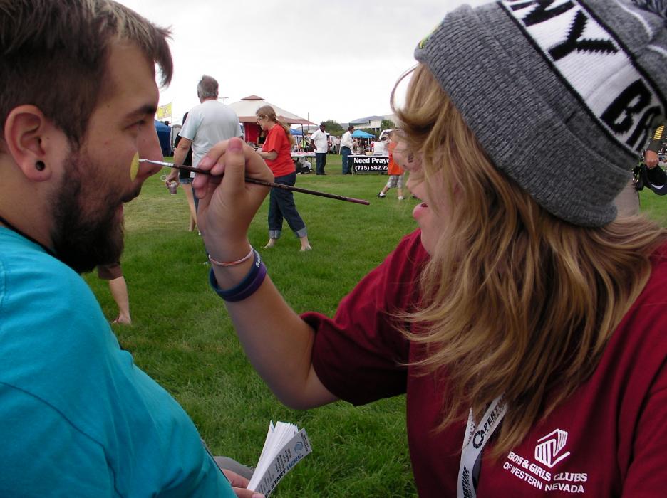 Boys and Girls Club of Western Nevada staffer Daniel Dilegame gets his face painted by Chelsea Phillips.