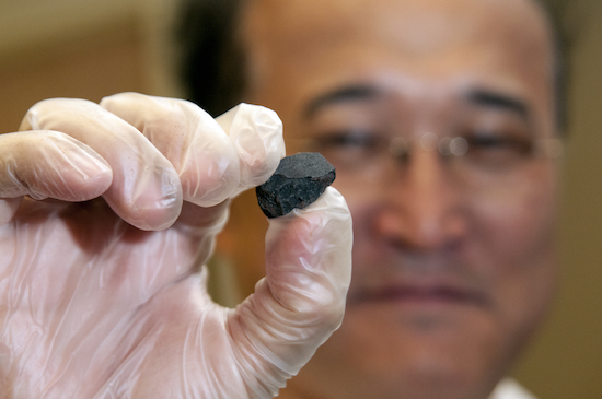 UC Davis geology professor Qing-zhu Yin holds a fragment of the Sutter's Mill meteorite.