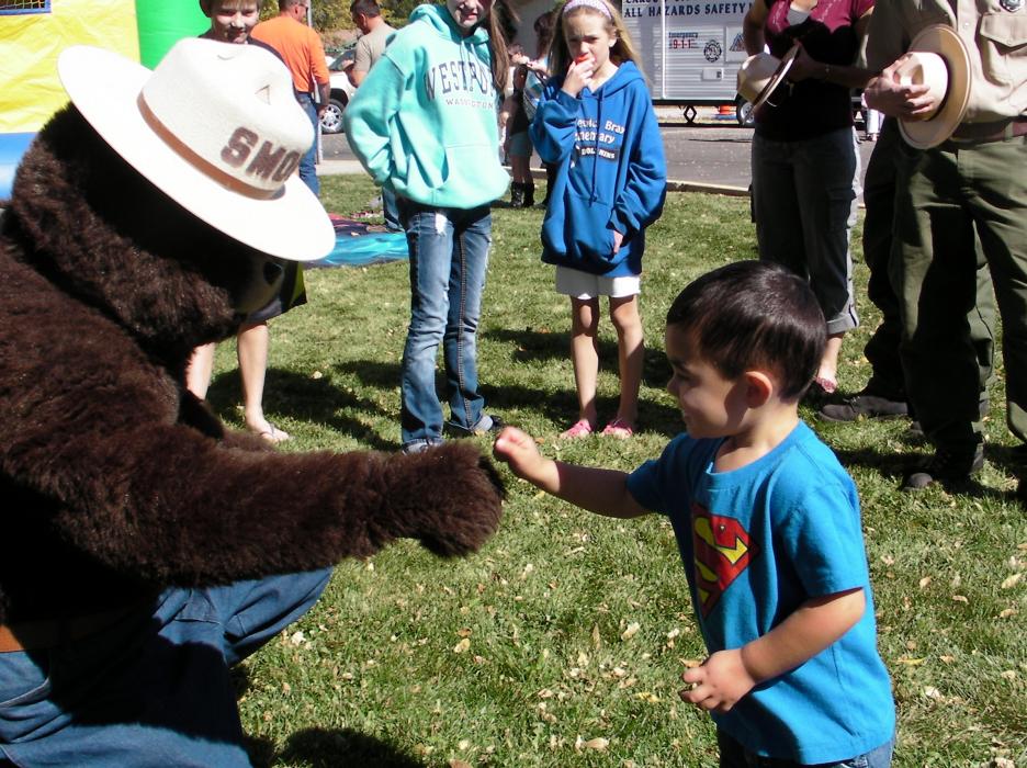 Landon Gauge-Kizer, 3, gets a fist bump from Smokey Bear.