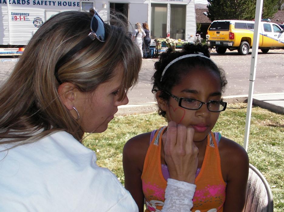 Elisa Danen applies face paint to Britttany Gray, 12.