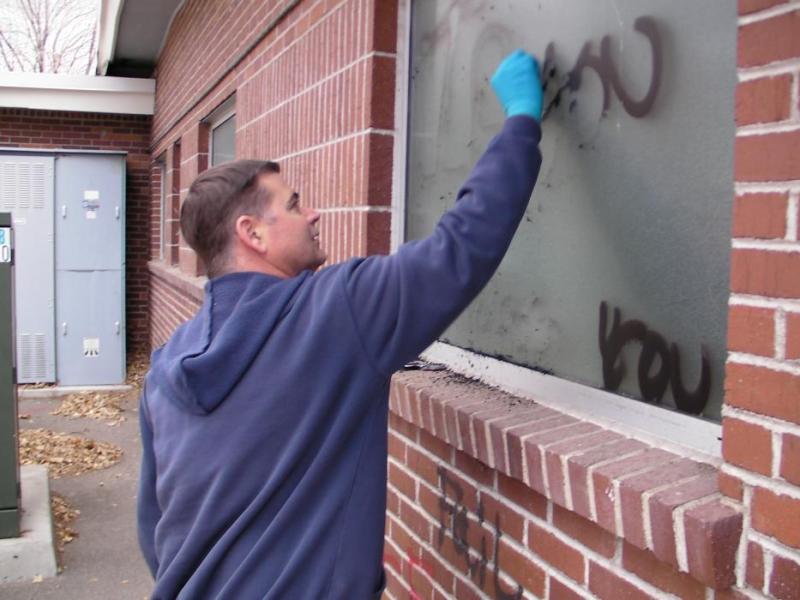 Carson City School District maintenance worker Paul Mason scrubs a building that was vandalized.