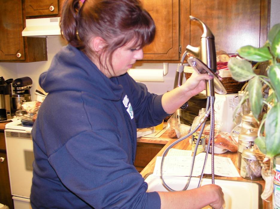 Genna Tonneslan, Account Manager at Quick Space installs a new faucet.