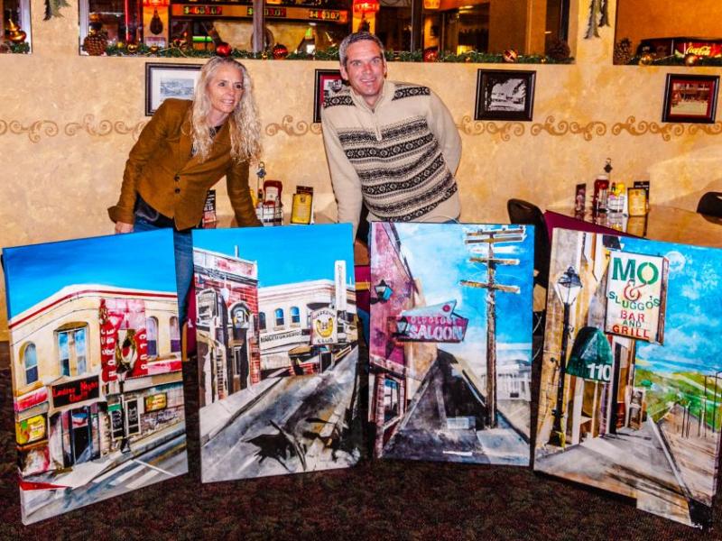 Pam Black and Jeff Pace with the paintings of the Horseshoe now and in the 1970's, the Old Globe and Mo and Sluggo's.