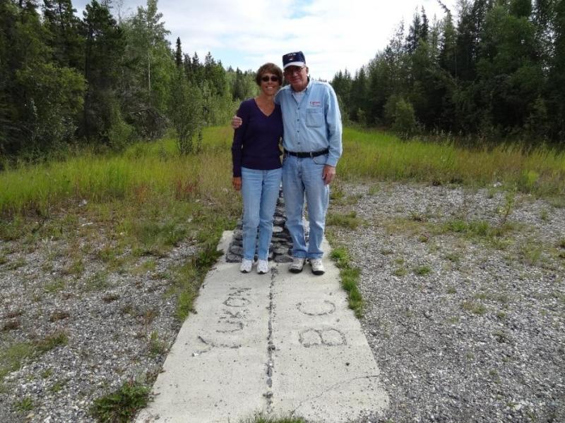 Don and Elaine Quilici standing at the boundary of British Columbia and the Yukon.  Photo by Susan Drury