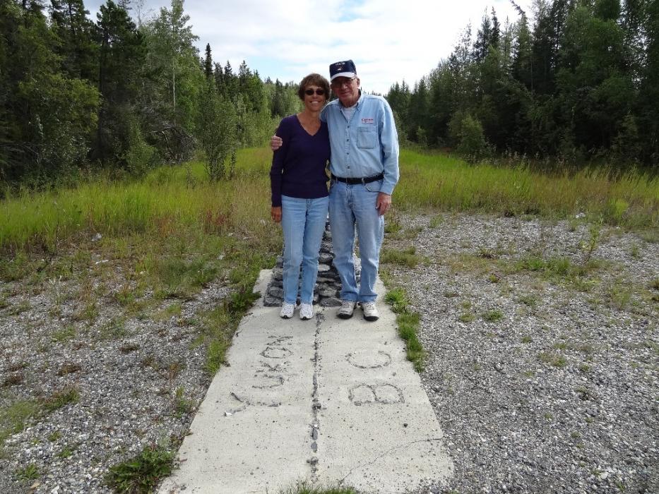 Don and Elaine Quilici standing at the boundary of British Columbia and the Yukon.  Photo by Susan Drury