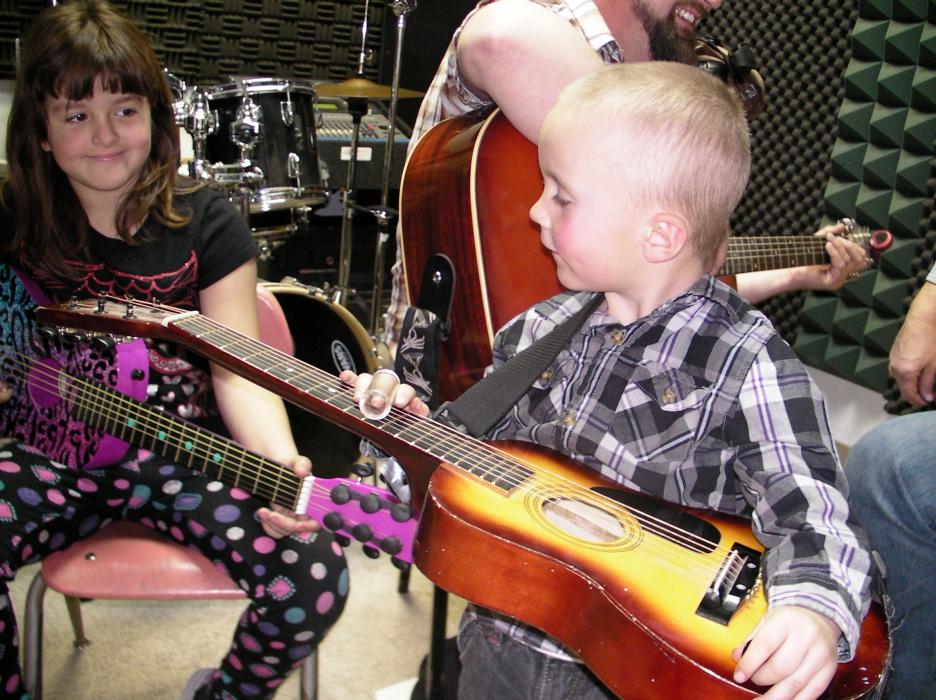 Morgan Bailey, left, and her brother Hank, right, improvise while their father Josh gets a lesson at Play Your Own Music.