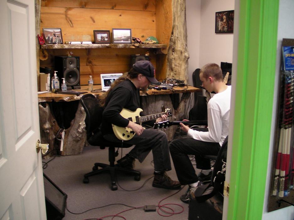 Musician and guitar instructor Curt Mitchell, left, teaches a student.