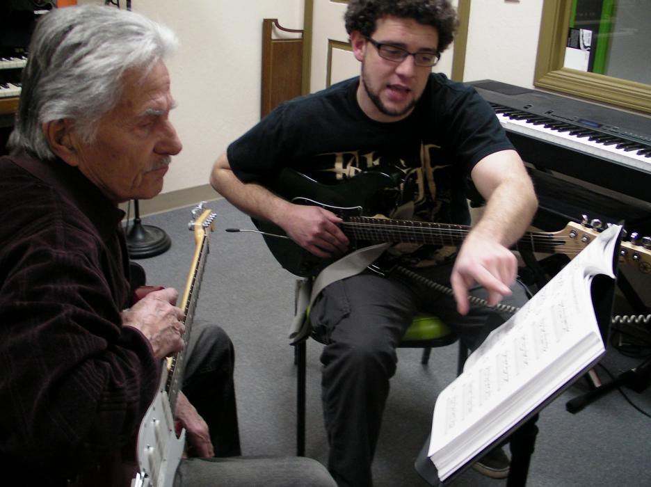 Larry Swinburg, left, gets a lesson from guitar instructor Jim Gustafson.