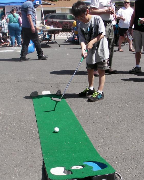 Jake Xie takes a turn on the putting rug provided by Empire Ranch Golf Course.