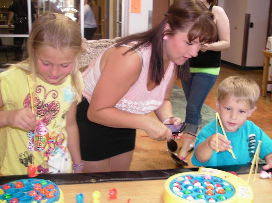 L to R: Trinity Davis, Courtney Hentzenig, and Trent Davis play a wheel game inside the sheriff's office.