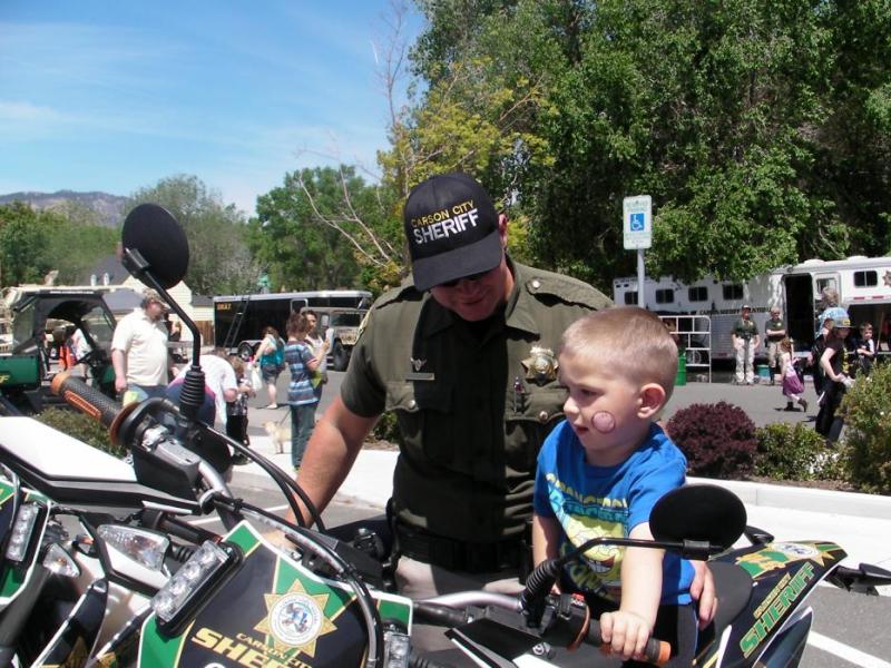 Carson City sheriff's motor patrol deputy Joey Trotter helps Nehemiah Feagan, 3, on a motorcycle Saturday..