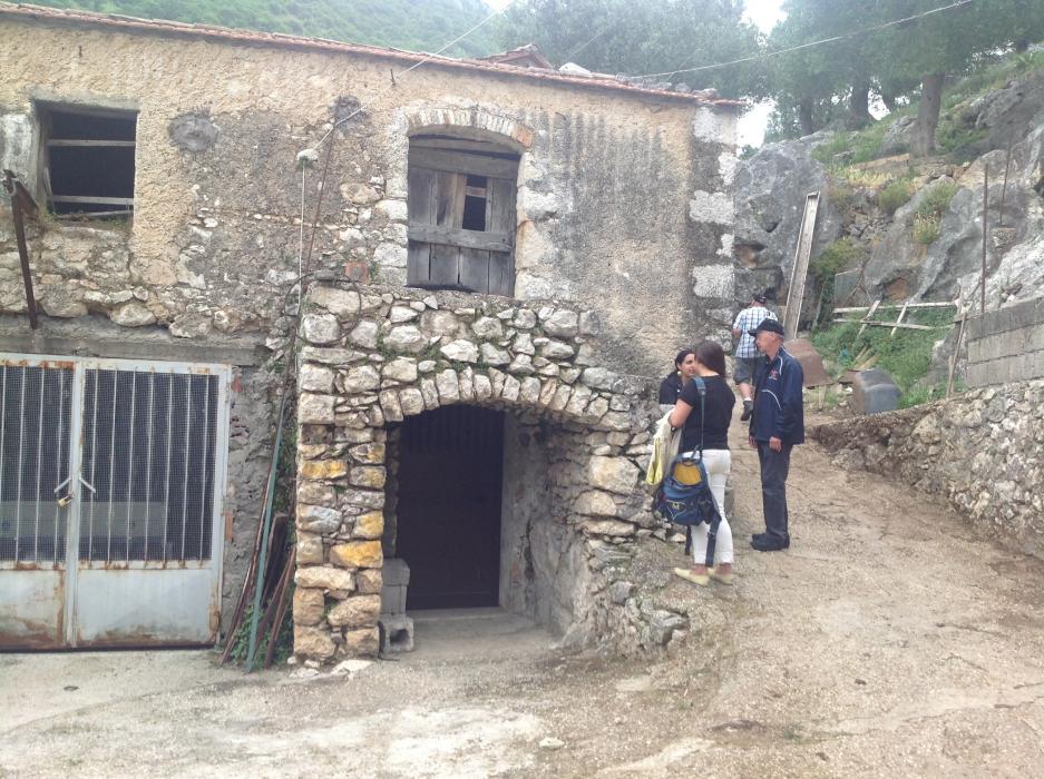 The same building in May 2014 with the balcony removed and the opening boarded. Four members of the tour are on the path.