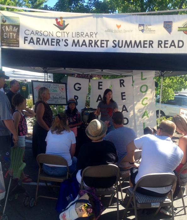 Lisa Keating-McEllistrem answering questions about backyard chickens from the Library's pop-up classroom at the farmers market.