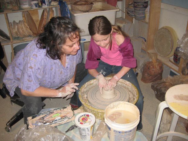 Robin McGregor, owner of Carson City Pottery assists a student.