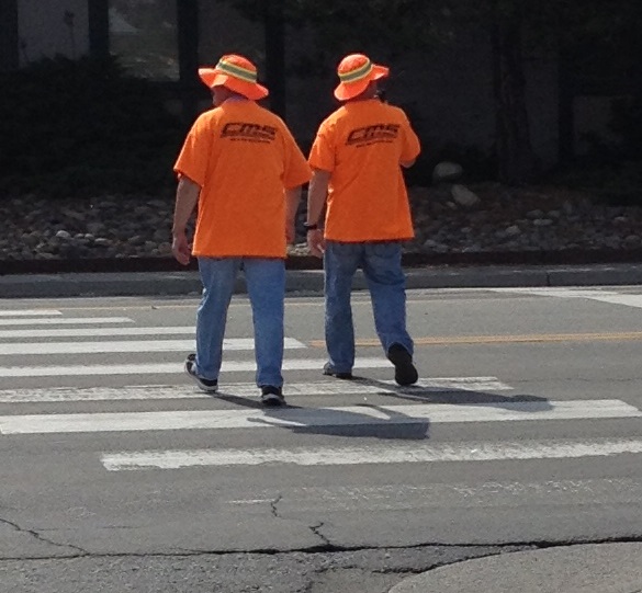 Two Carson City sheriff's deputies, dressed in bright orange, walk across Carson Street during the operation.
