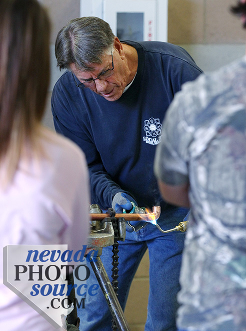 John Williams gives a plumbing demonstration to a group of Silver Stage High School students.