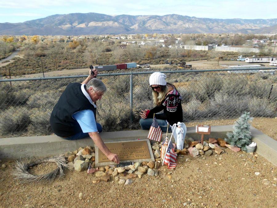 John Warne and granddaughter Kylie at Danny's marker. John is looking at empty rifle shells left at the marker.
