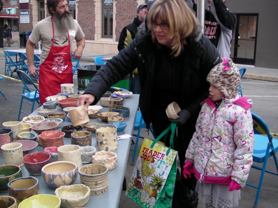 Susan McElfish and granddaughter Della, 6, look through a table of homemade crafted bowls.