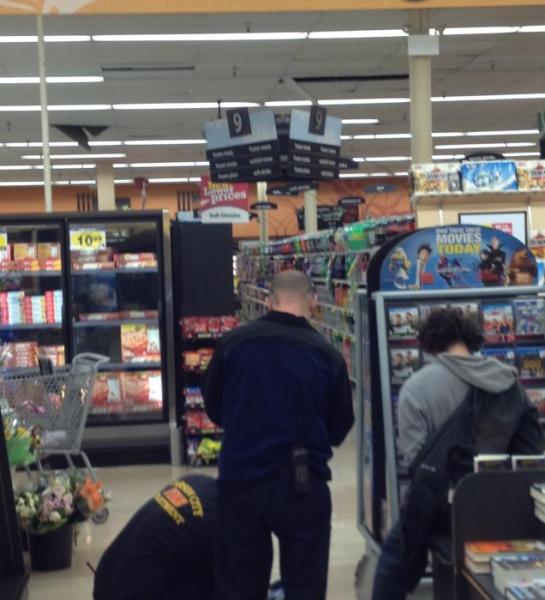 Officers and medics at the scene, the suspect is on the right. The ceiling tiles are broken in two places.