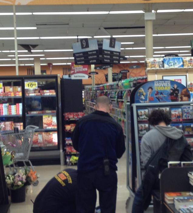 Officers and medics at the scene, the suspect is on the right. The ceiling tiles are broken in two places.