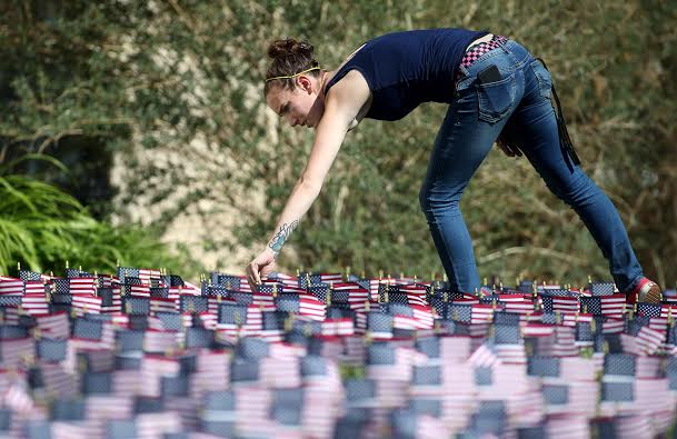 Kayla Hannifan, a volunteer, helped plant flags Friday at Western Nevada College in Carson City. Photo by Cathleen Allison, Nevada Photo Source