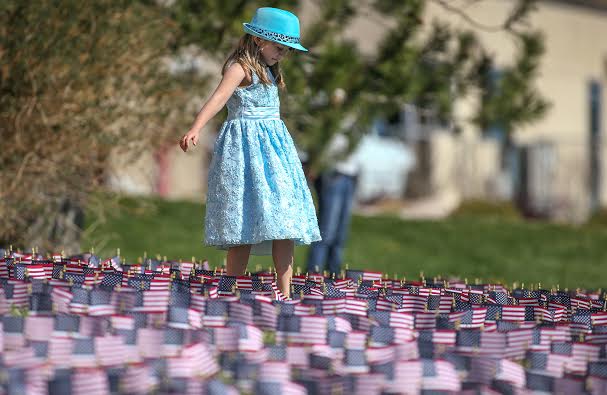 Jaelynn Smith, 6, helped plant flags Friday at Western Nevada College front lawn. Photo by Cathleen Allison, Nevada Photo Source