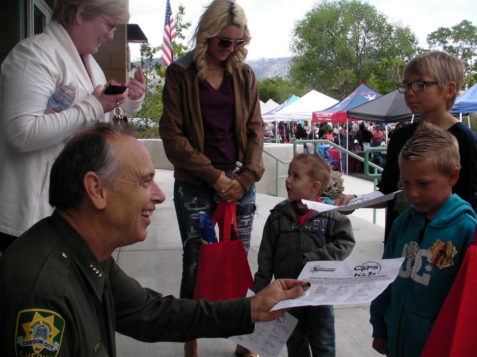 Carson City Sheriff Ken Furlong greets kids for the sign-in for prizes at the end of the day.