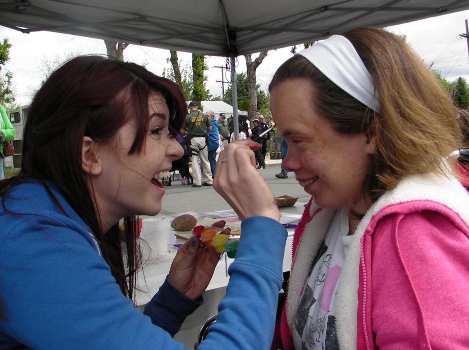 Face painter Emily Fernandez prepares participant Rene with a Spiderman surprise.