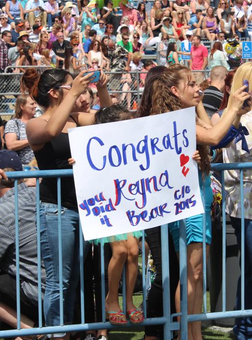 Families display posters congratulating their young graduates.