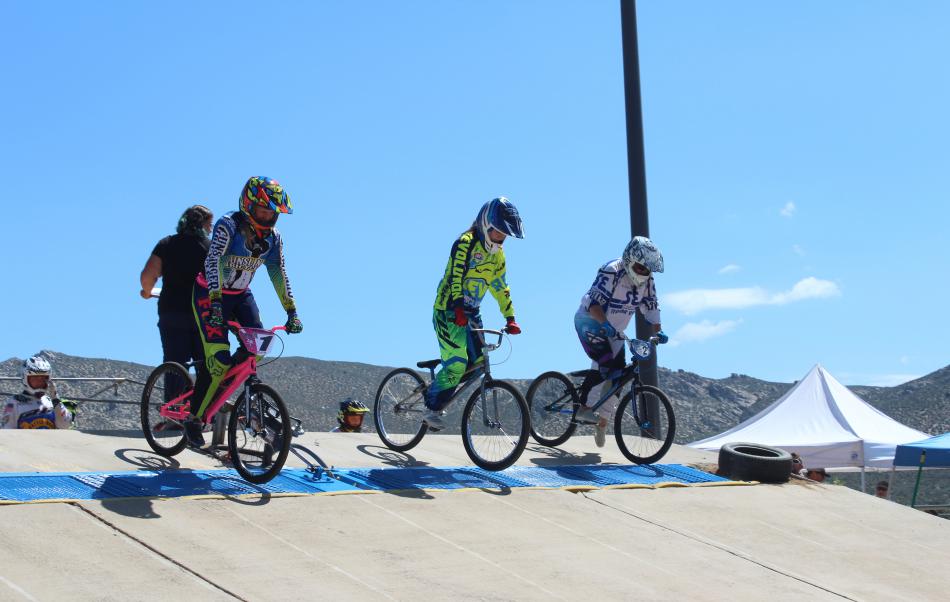 As the gate crashes down the racers get up on their bikes to gain momentum early in the race.
